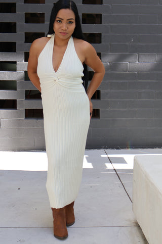 Woman in a white dress standing in a modern architectural setting