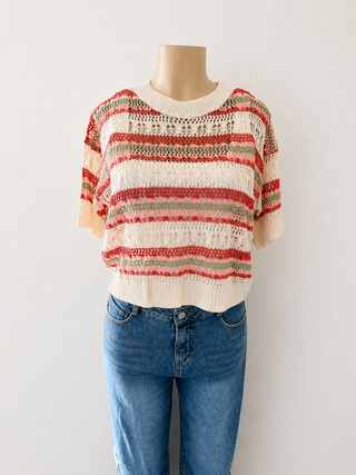 A short-sleeve knit sweater with horizontal stripes in cream, red, and green, displayed on a mannequin torso with blue jeans against a plain light background.