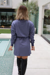 Person wearing a purple coat standing by a poolside.