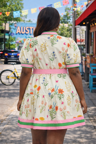 Woman wearing a floral dress with a city street background