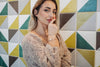 Woman posing against a geometric tile wall