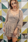 Woman wearing a patterned dress against a geometric tile wall