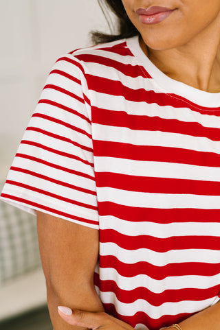 A close-up of a woman wearing a red and white horizontally striped short-sleeve t-shirt.
