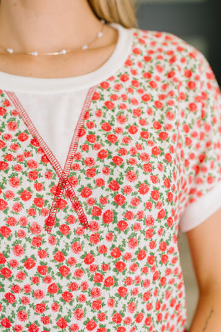 Close-up of a floral dress with red flowers on a white background