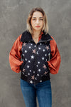 Woman wearing a jacket with star pattern against a gray background